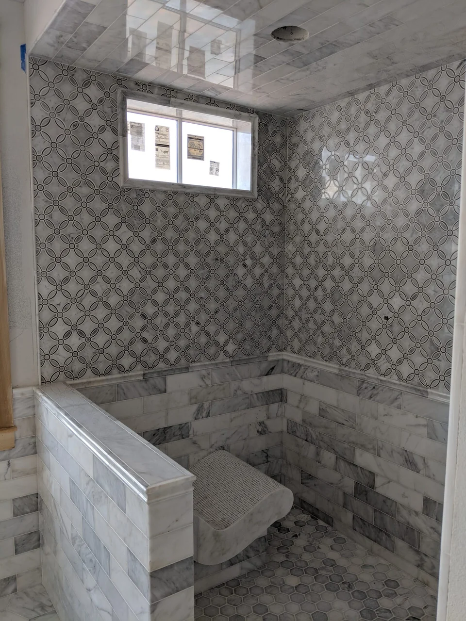 Patterned shower wall and curved mosaic bench