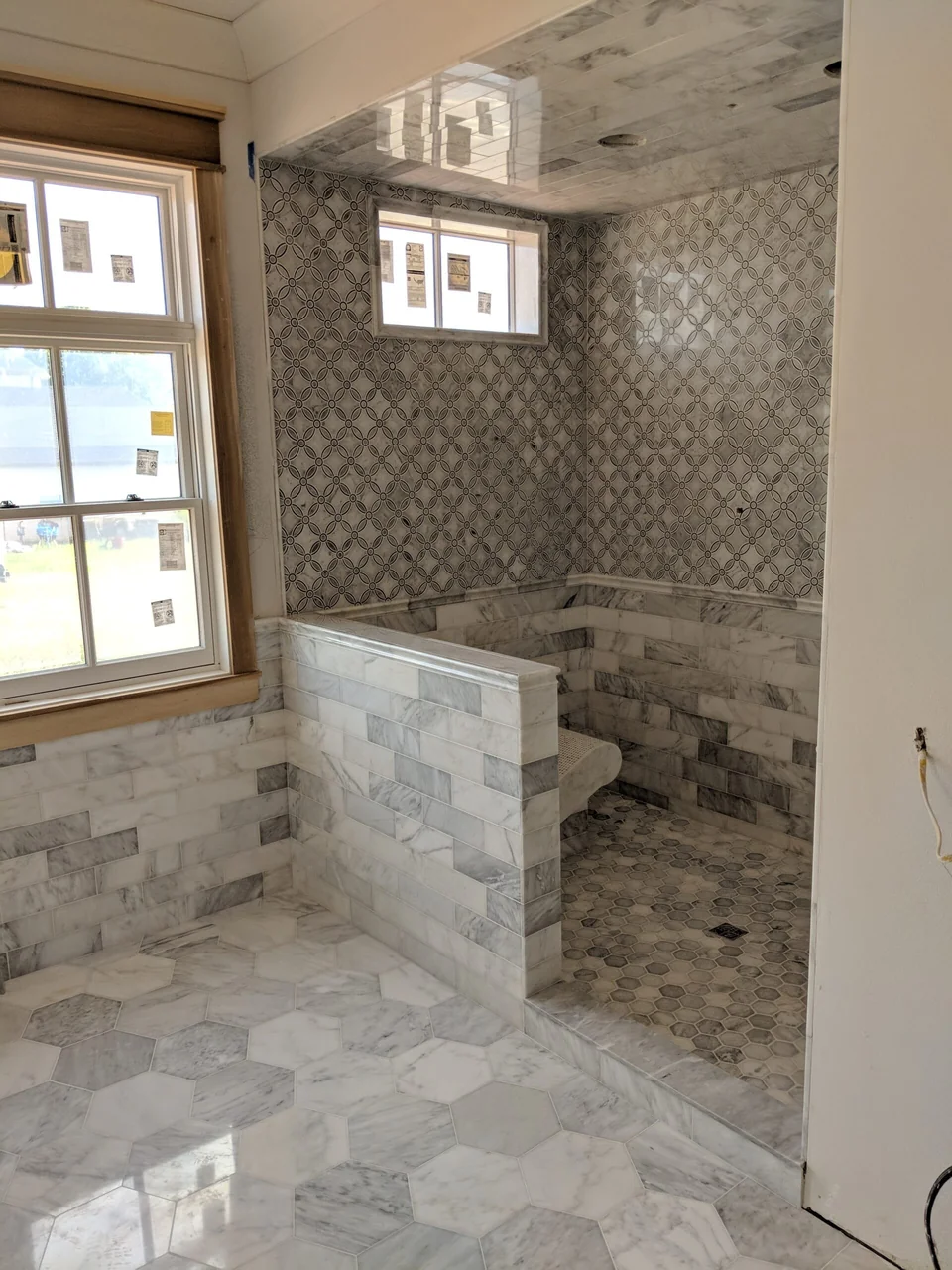 Custom stone and patterned tile shower with polished surfaces