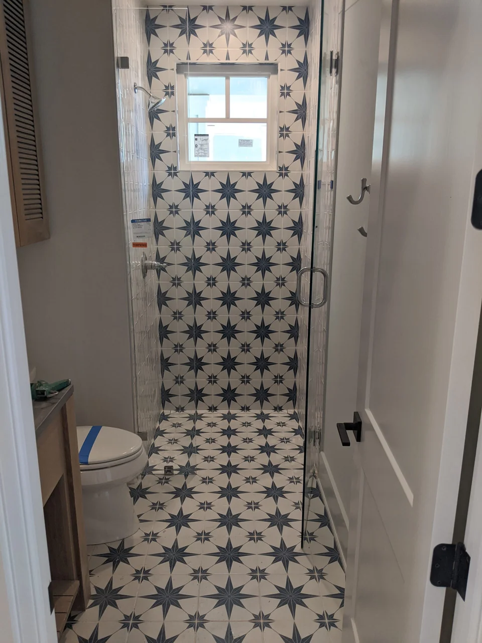 Blue star-pattern tile on the shower wall and bathroom floor