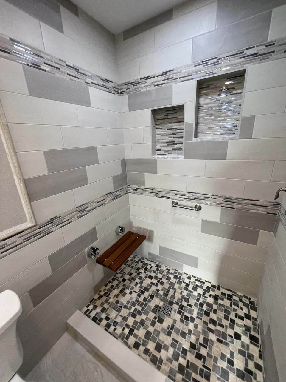 Tiled shower with folding seat and grab bars