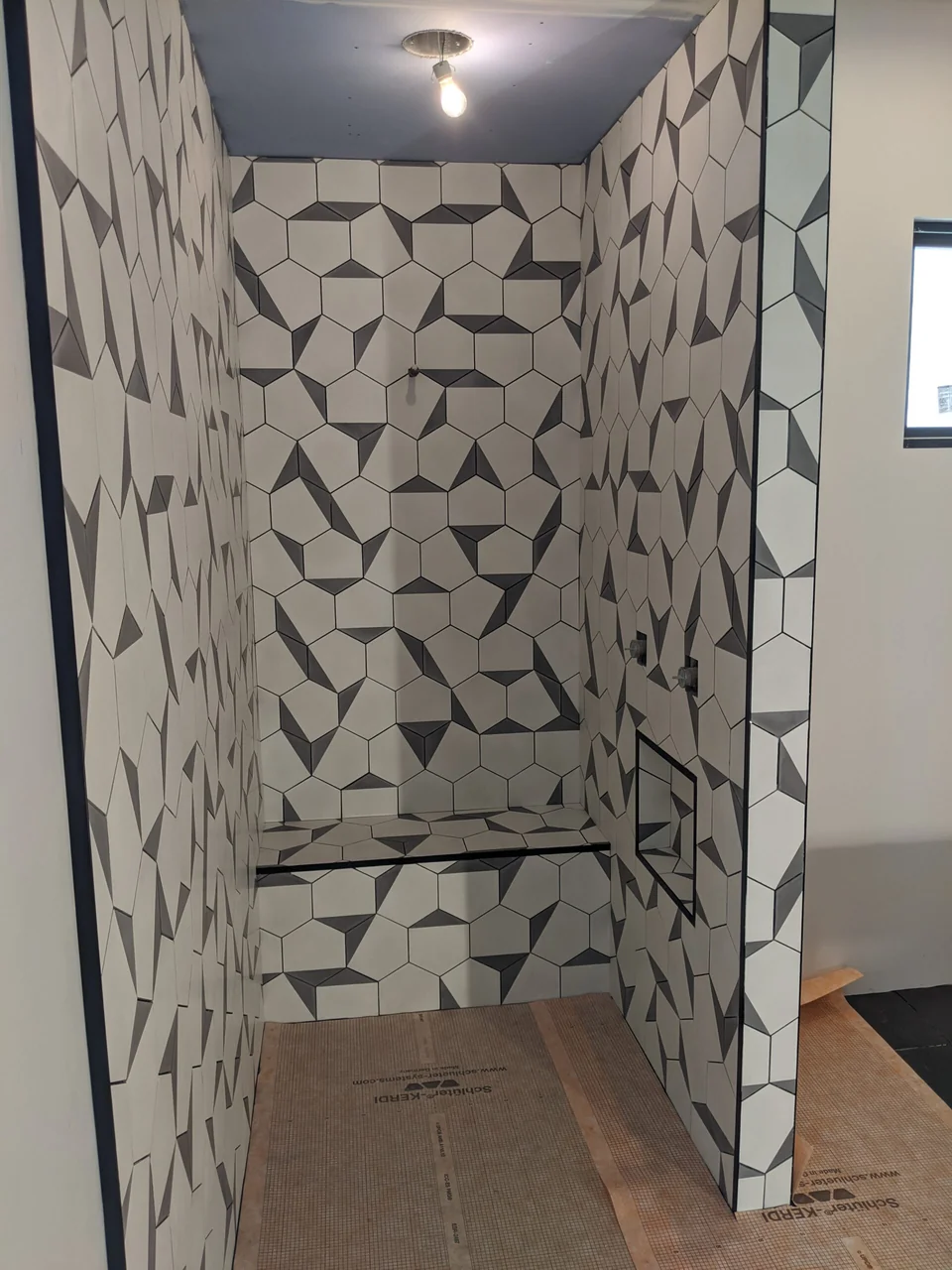 Geometric stone tile on three shower walls