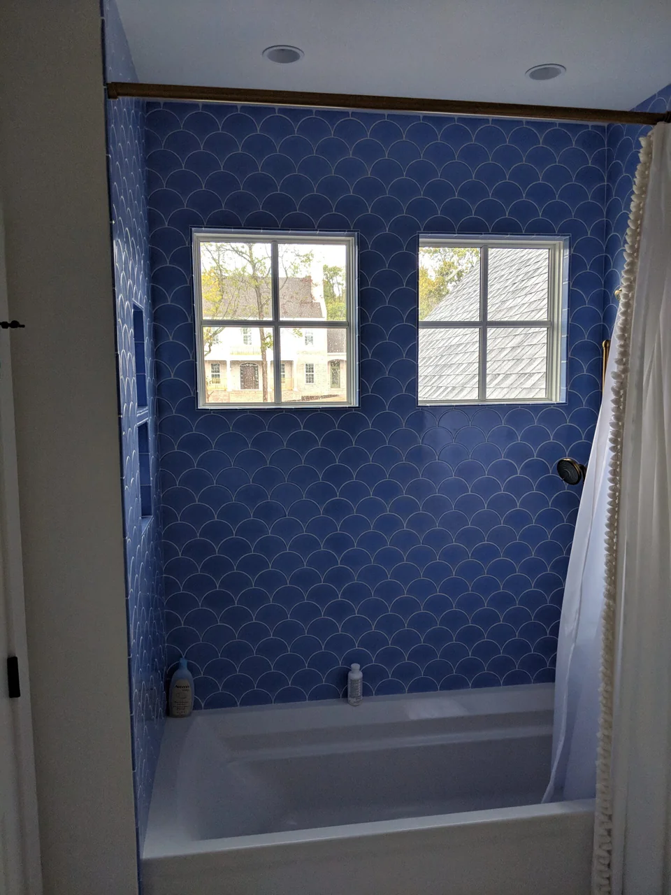 Blue scallop tile around the tub and window