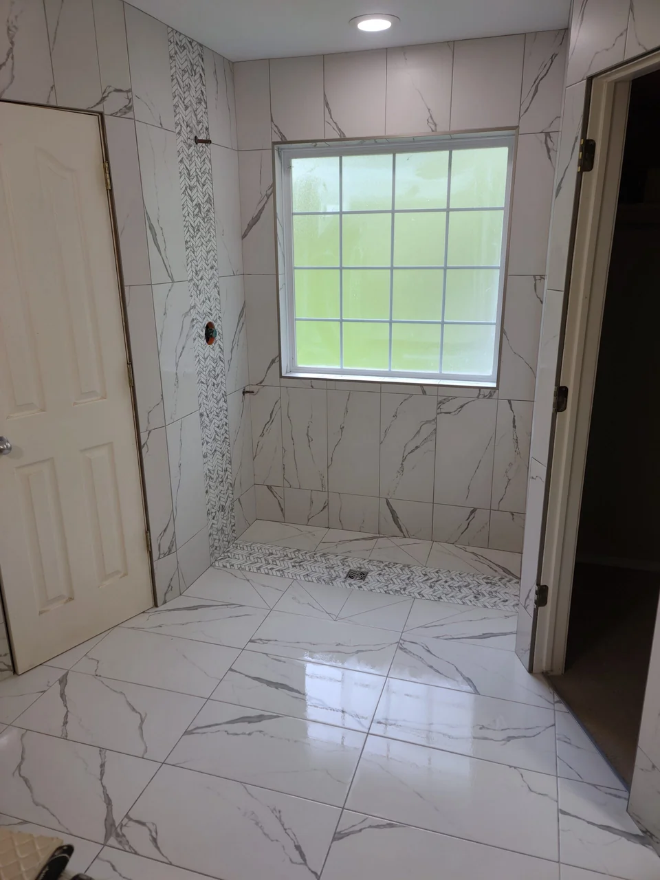 Veined tile walls around a shower window