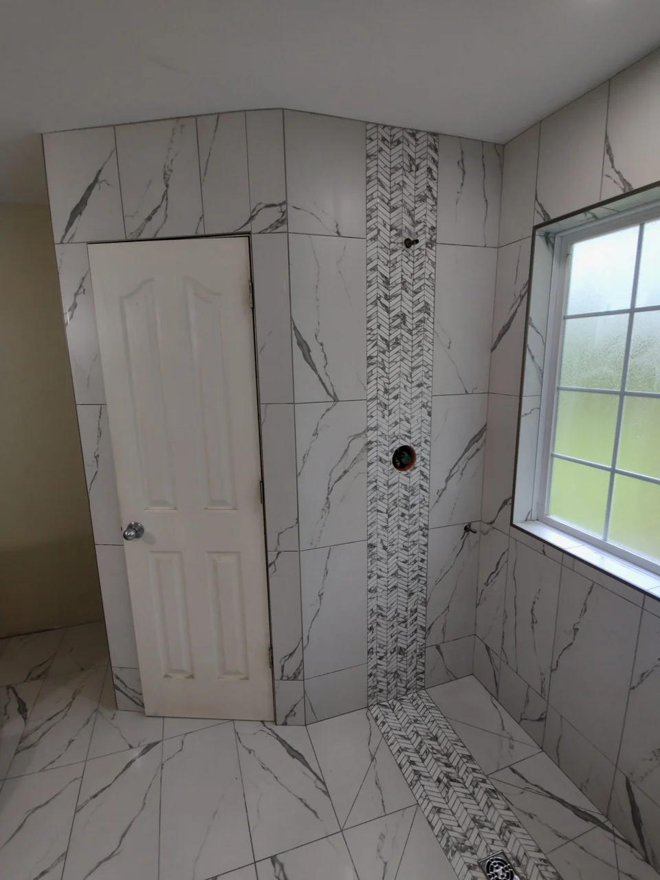 Shower fixture wall in large veined tile