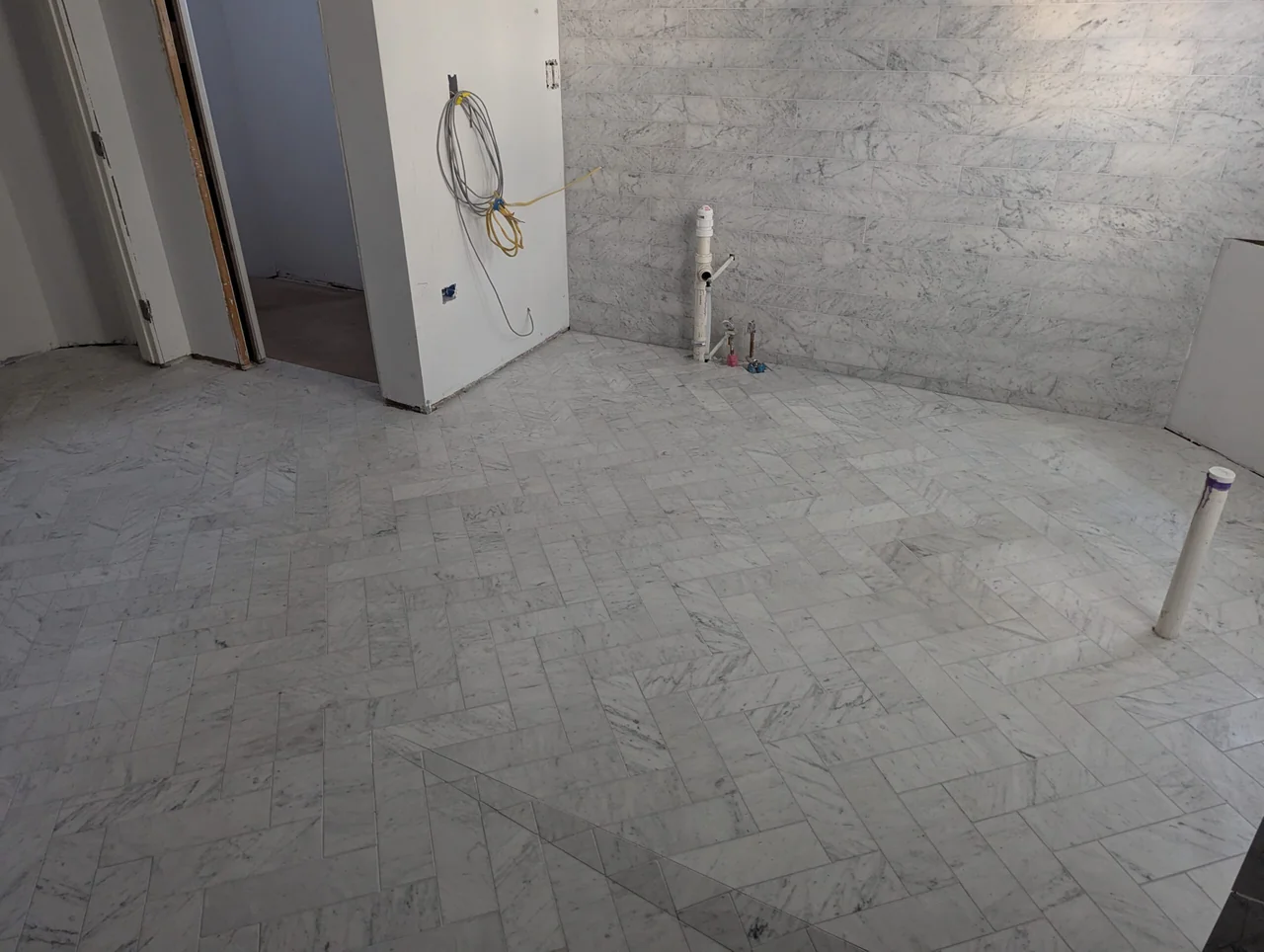 Pale tiled bathroom floor during installation