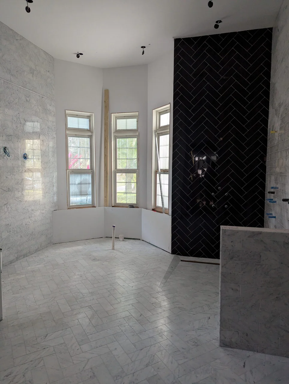 Pale bathroom tile and a contrasting black herringbone feature wall