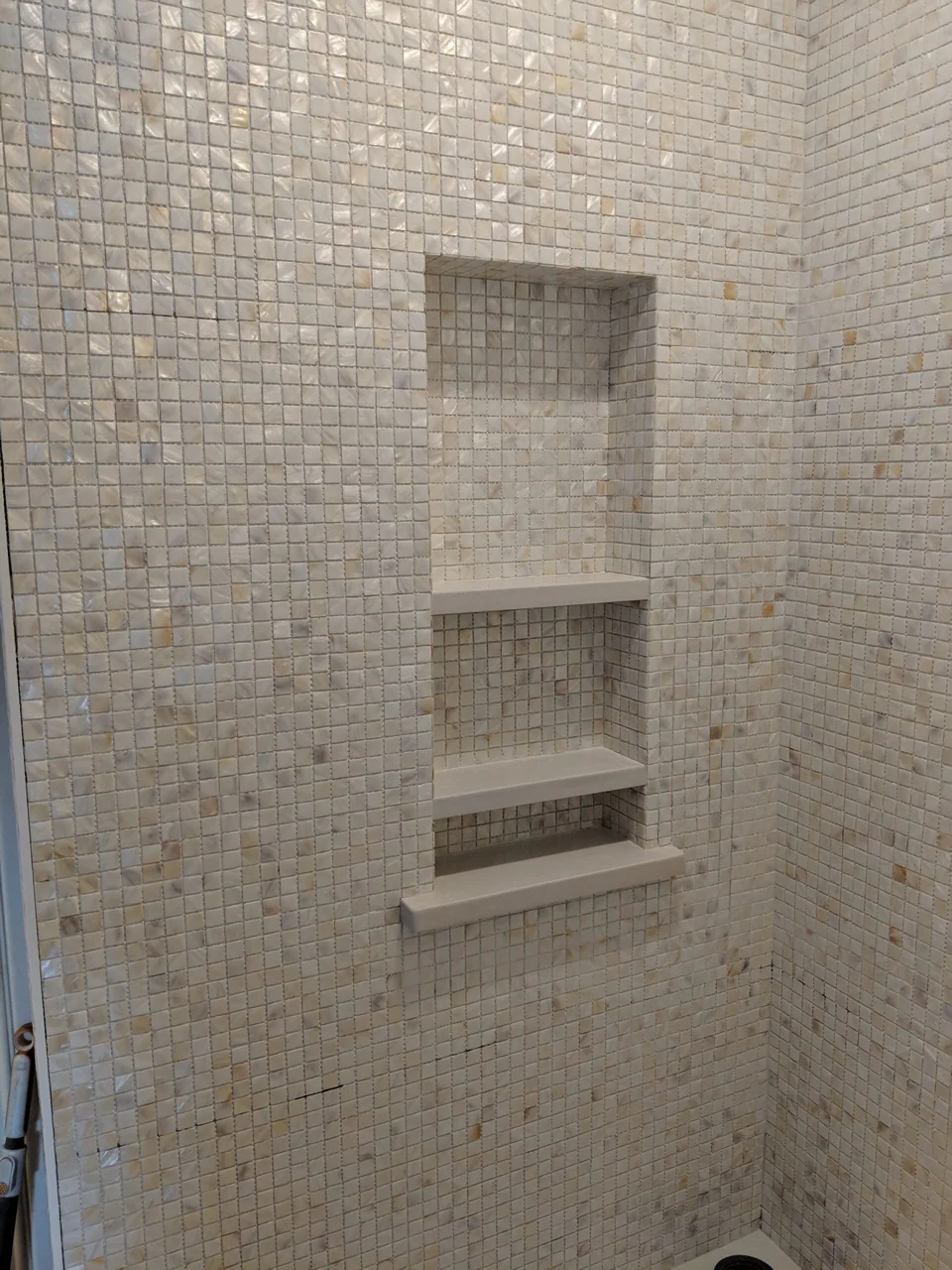 Close view of two mosaic-lined shower niches