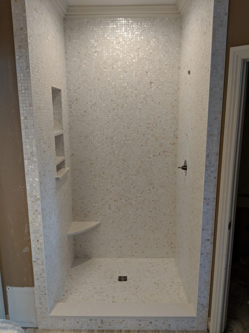 Mosaic tile shower with a corner seat