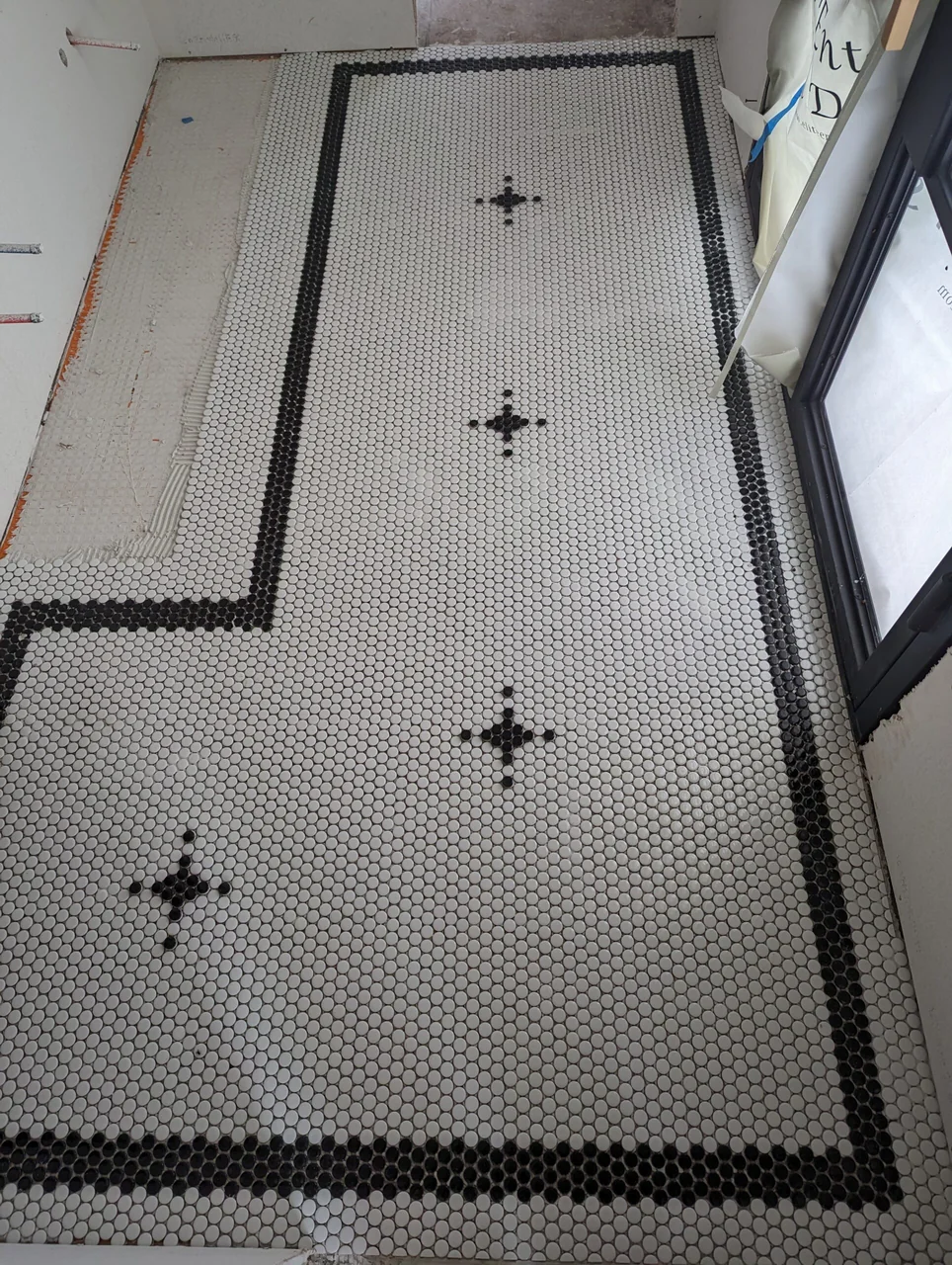 Small-format floor tile with a dark border and geometric accents
