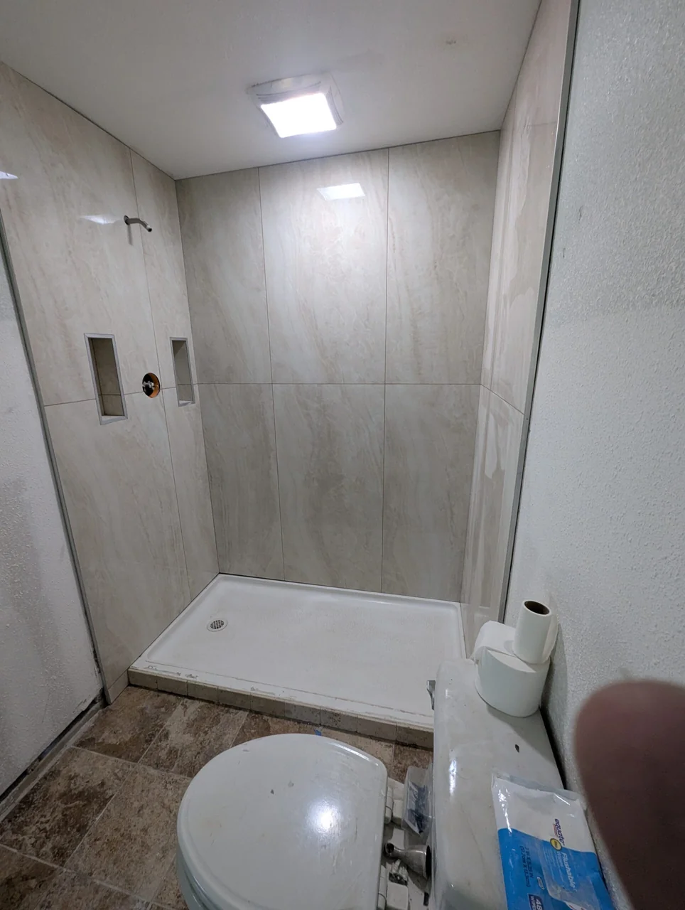 Large gray tile around a shower base