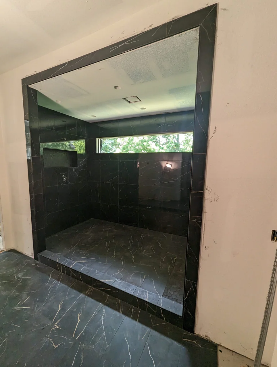 Dark tile shower with a broad window