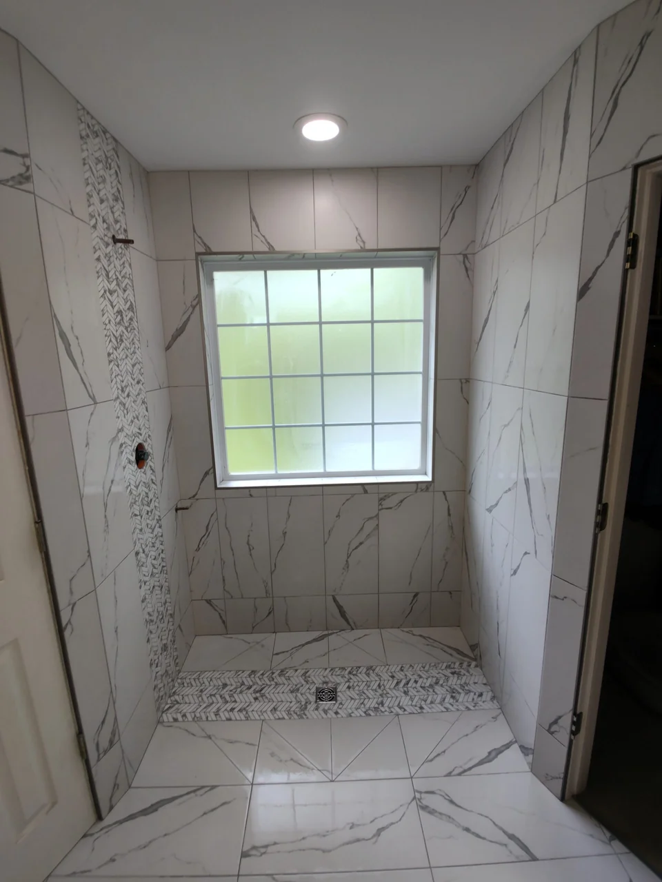 Full view of the veined shower tile and bench